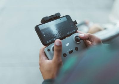 Radiocommande DJI dans les main du télépilote pour faire une inspection de toiture